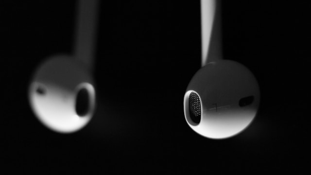 Image of iPods dangling against a black background